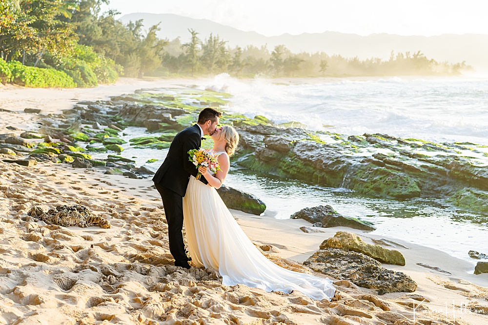 romantic oahu wedding pictures - bride and groom kissing on Oahu beach with ocean in the background 