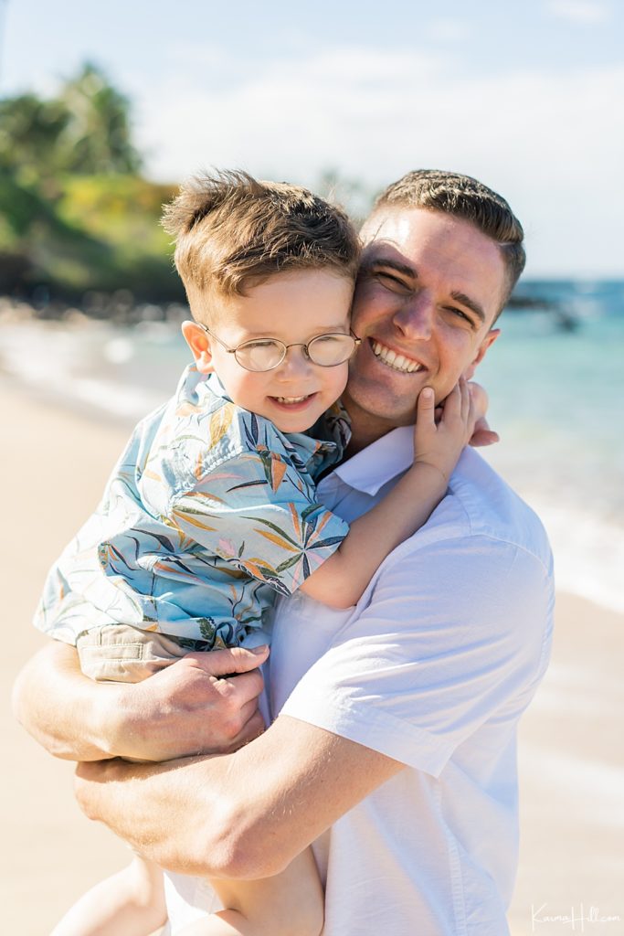 father and son hugging on maui beach 