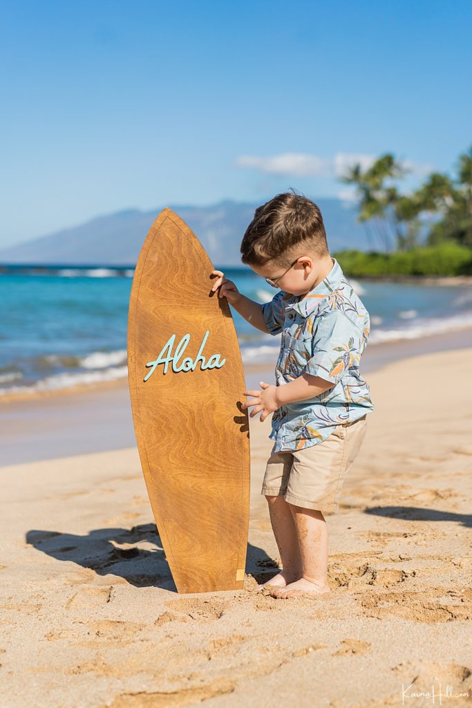 little boy holding an aloha surfboard on maui 