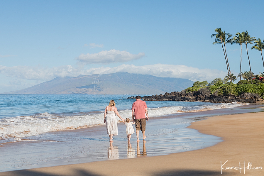 Family walking holding hands on maui beach 