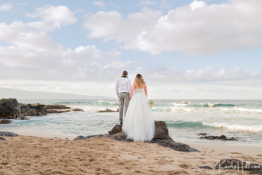 bride and groom on the beach overlooking an ocean 