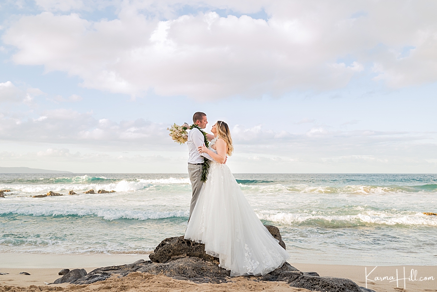 bride and groom with ocean in the background embracing each other 
