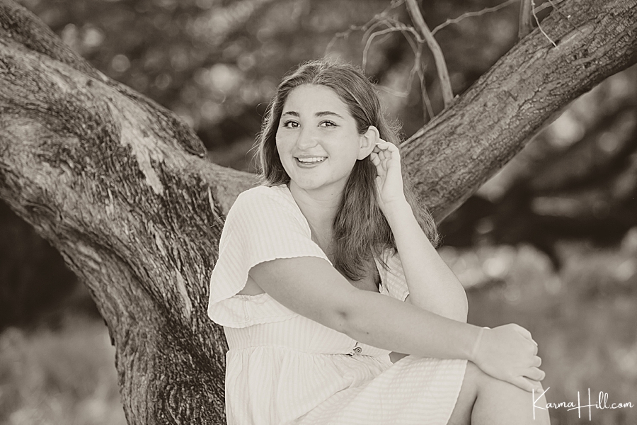 black and white image of a young woman in hawaii near a tree 