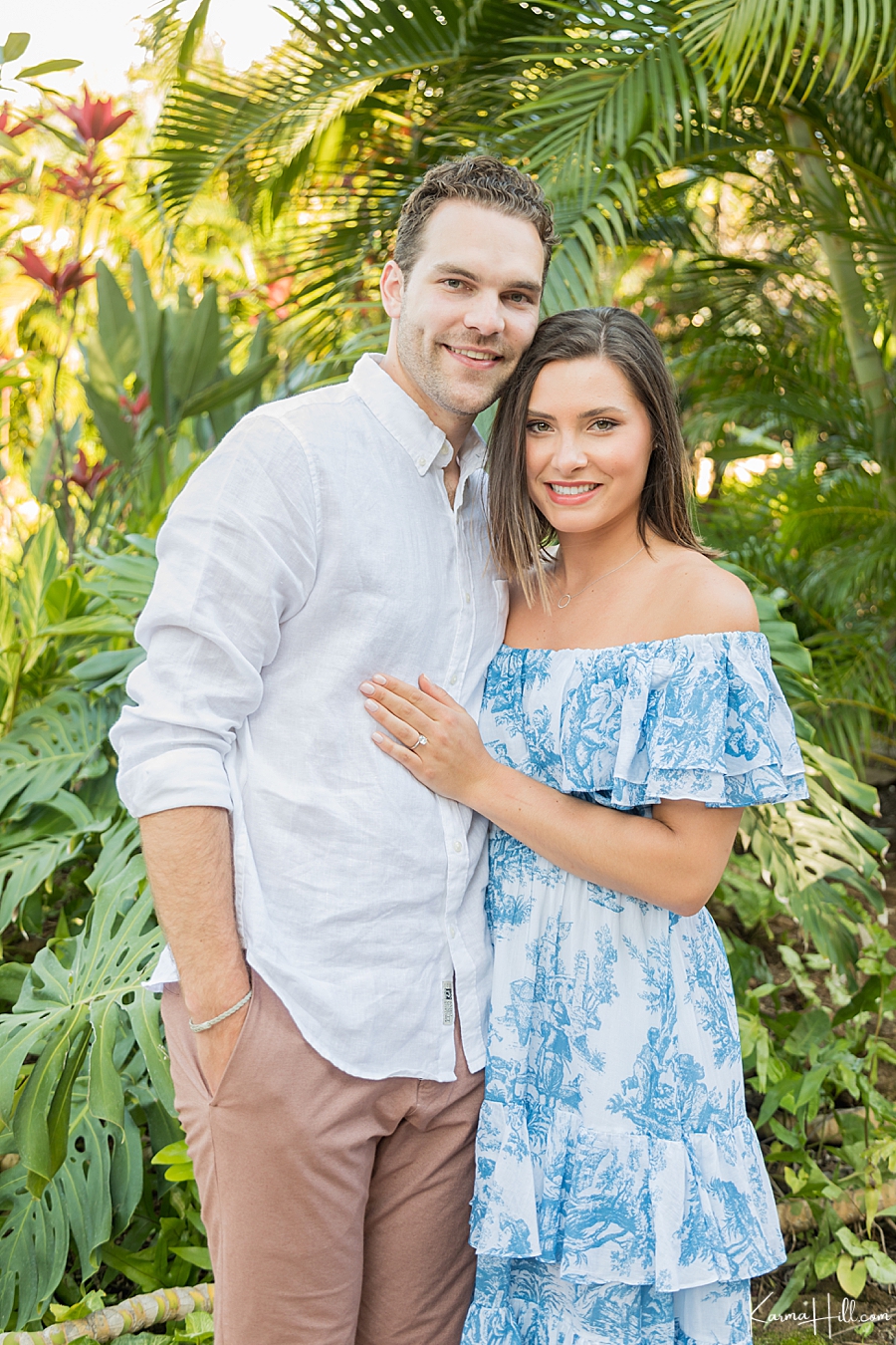 newly engaged couple pose in front of maui palm trees 
