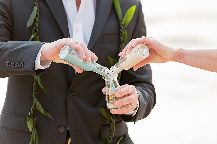 bride and groom pour bottles of sand together as symbol of union 