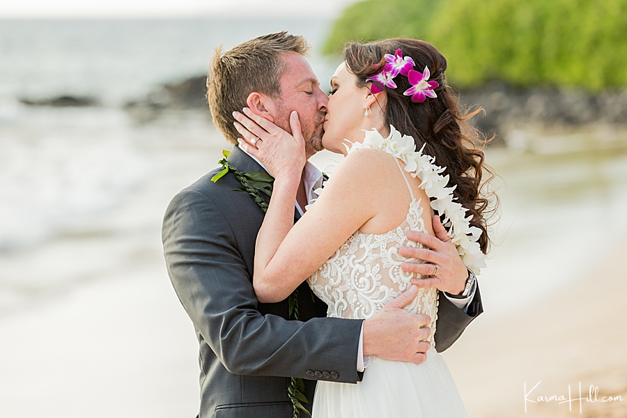 bride and groom kiss after their beach wedding in hawaii 