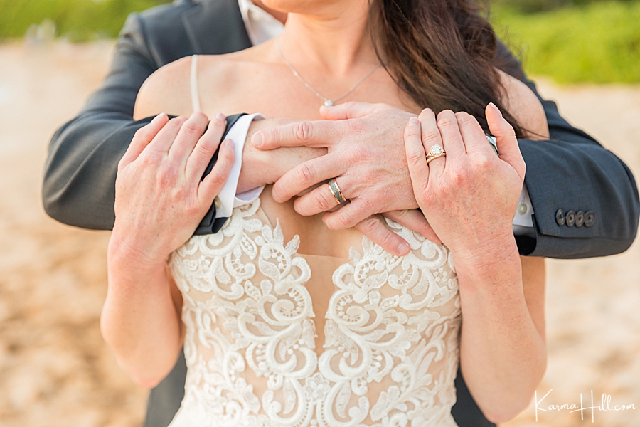 bride and groom embrace with close up of wedding rings 