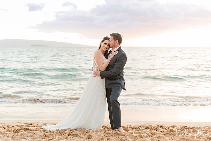 bride leans on groom during sunset in maui on beach 