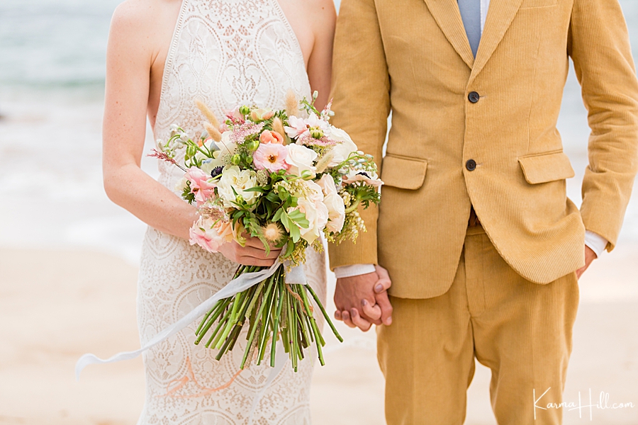 camel colored groom suite and boho bridal dress with peony flower bouquet 