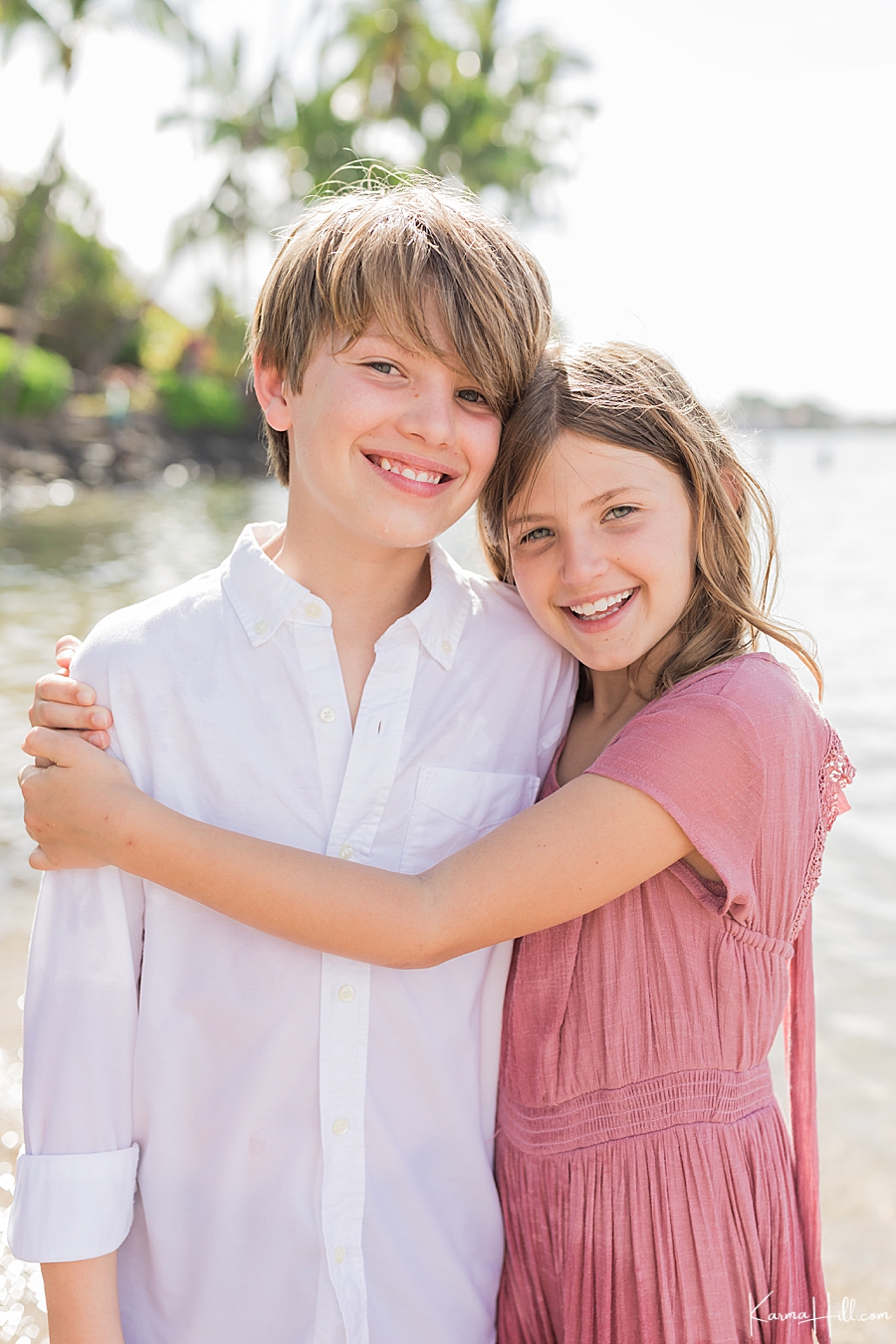 cute photos of a young brother and sister hugging on maui beach 