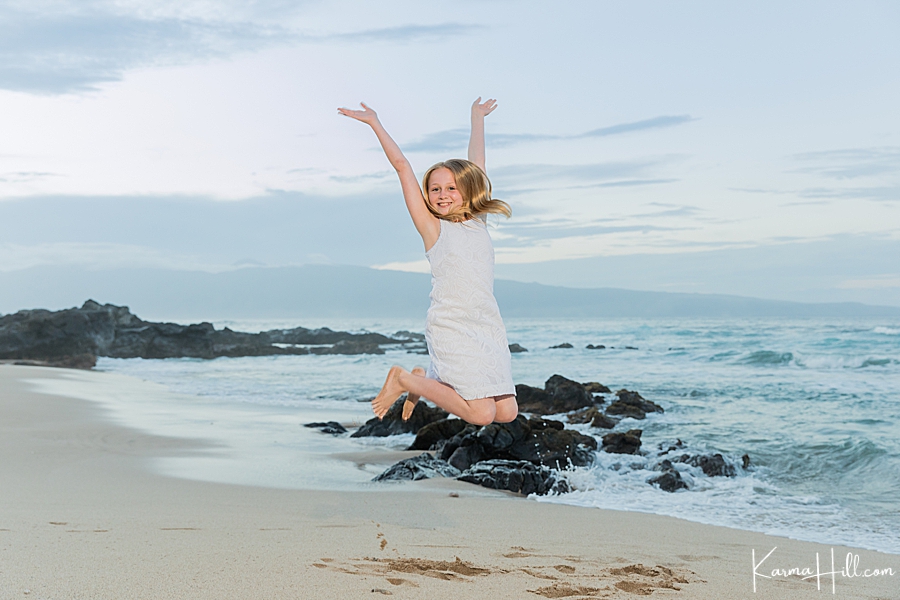 little girl jumps into the air during her maui family photo session 