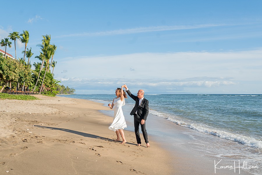 older couple celebrates their wedding by dancing on the beach in maui 