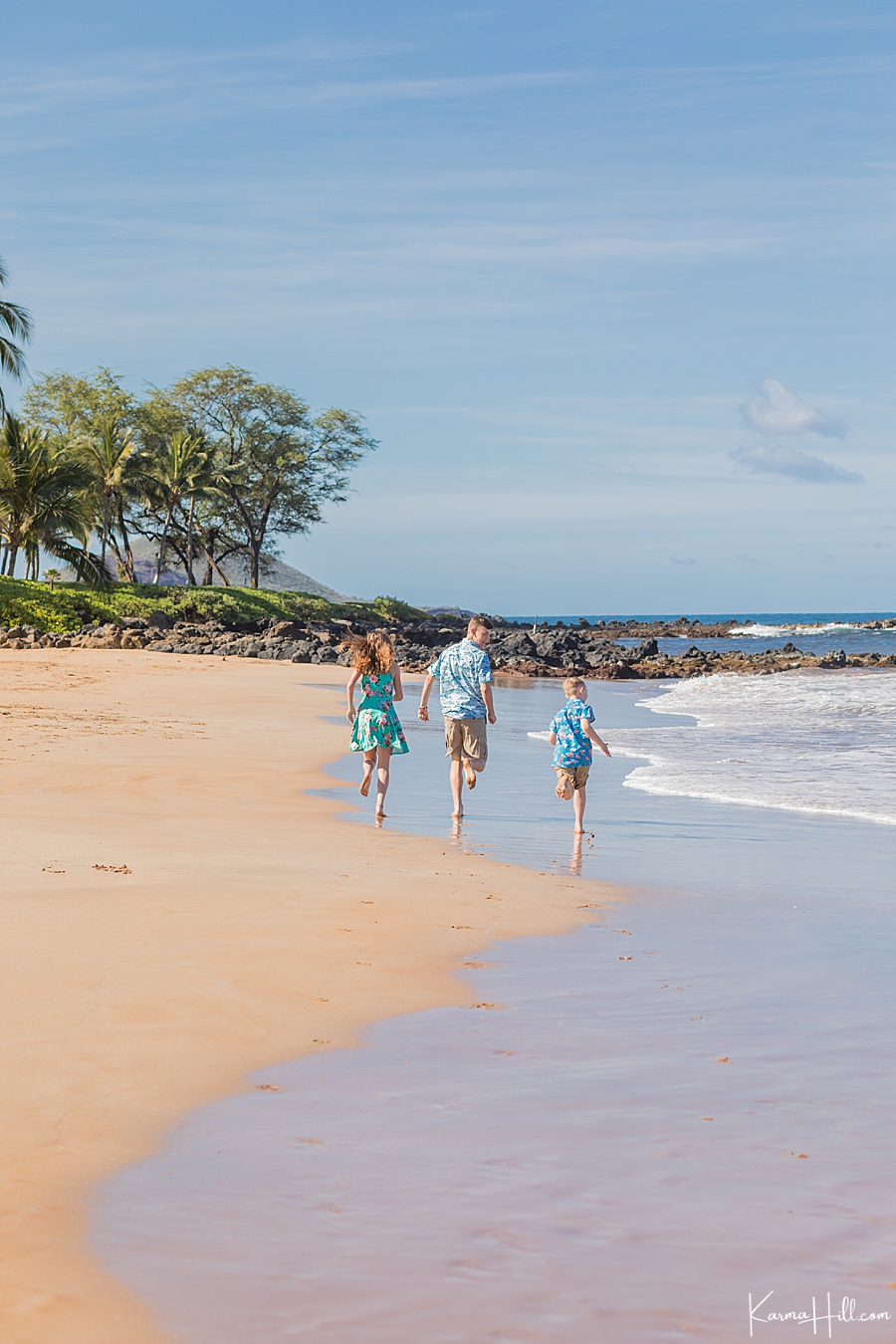 two brothers and their sister happily run from the camera during their family photos in hawaii 