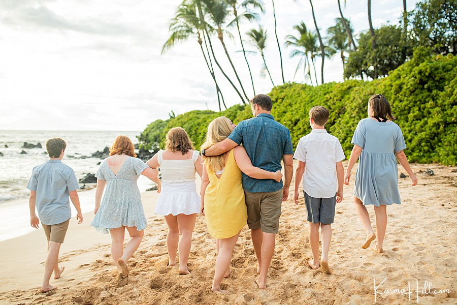 family of seven walk down a beach in maui 