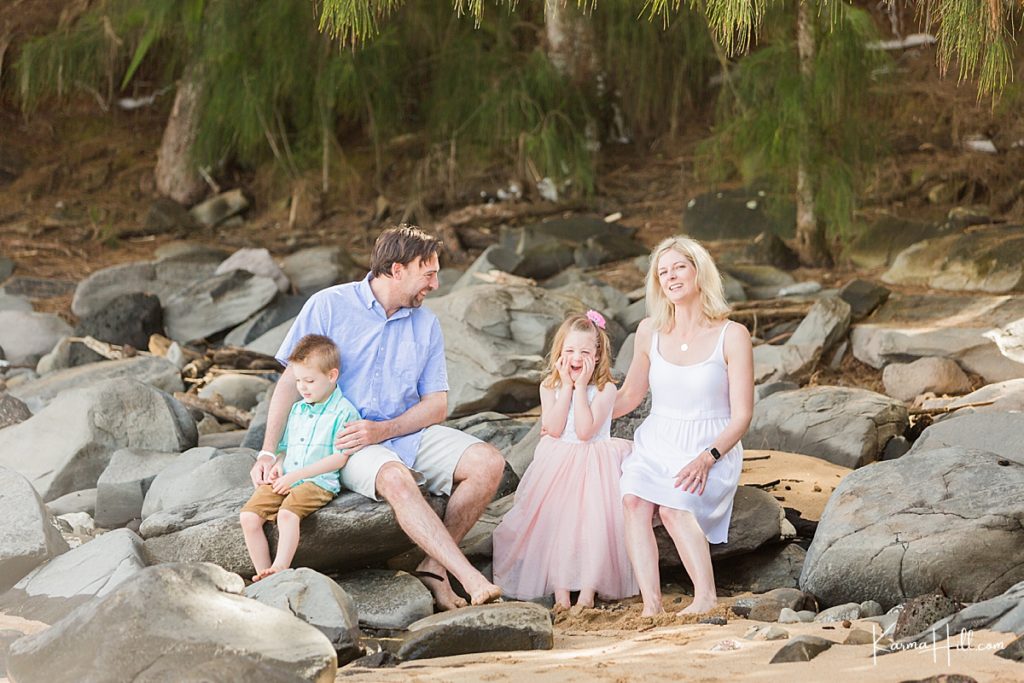 cute family photo on a rocky beach with family in pastels 