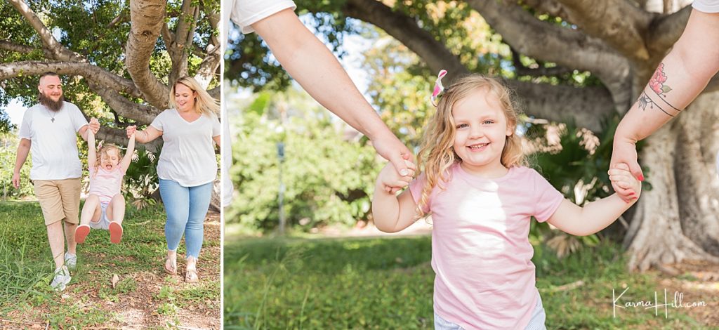 sweet little girl swinging on her parents arms during portrait session in hawaii 