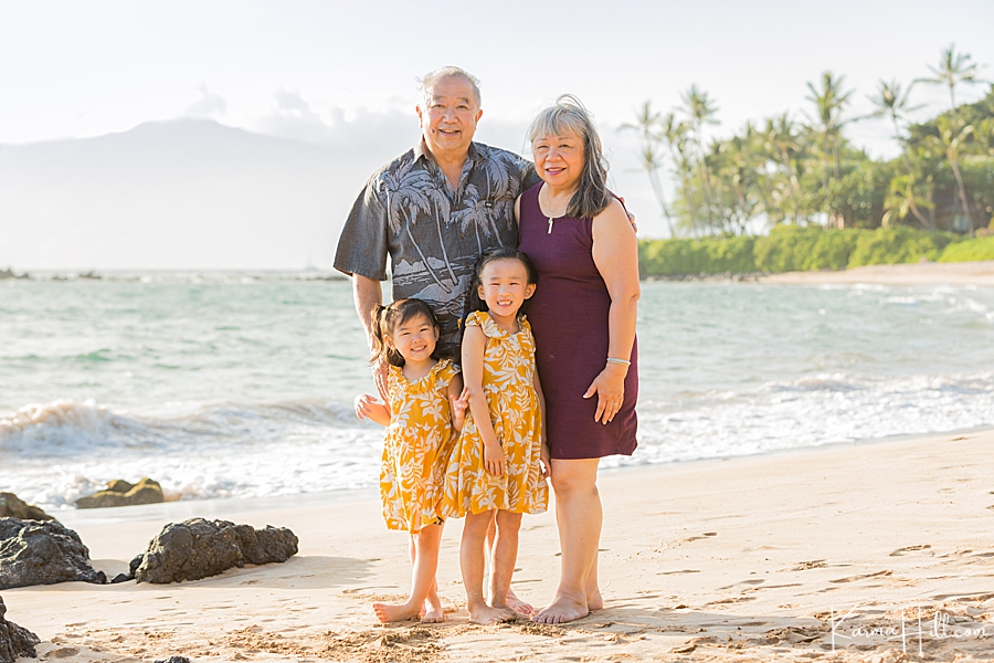 grandparents stand with their grandchildren on a maui beach 