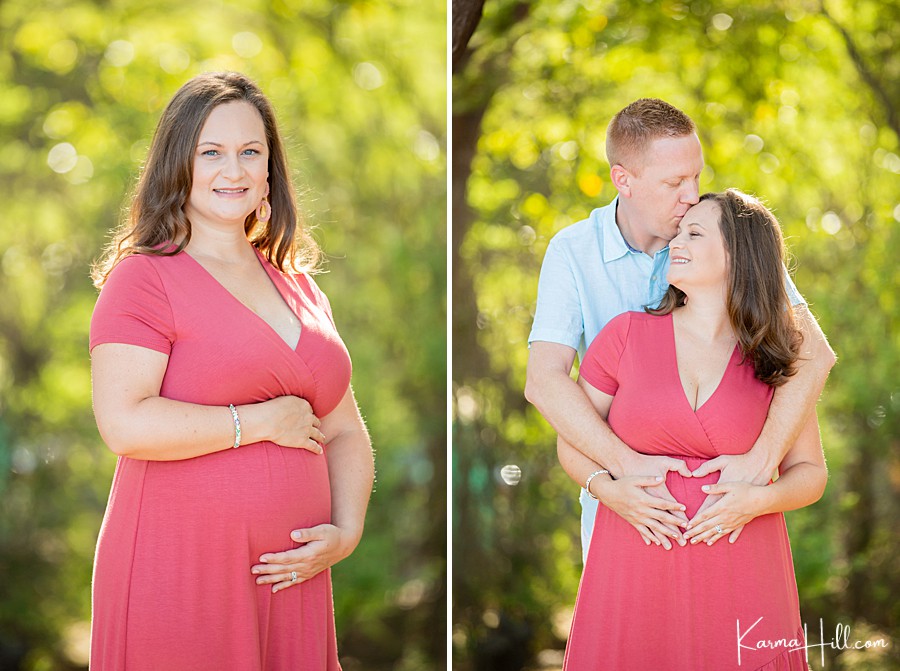 pregnant woman holds baby bump and father forms a heart around her belly with his hands 