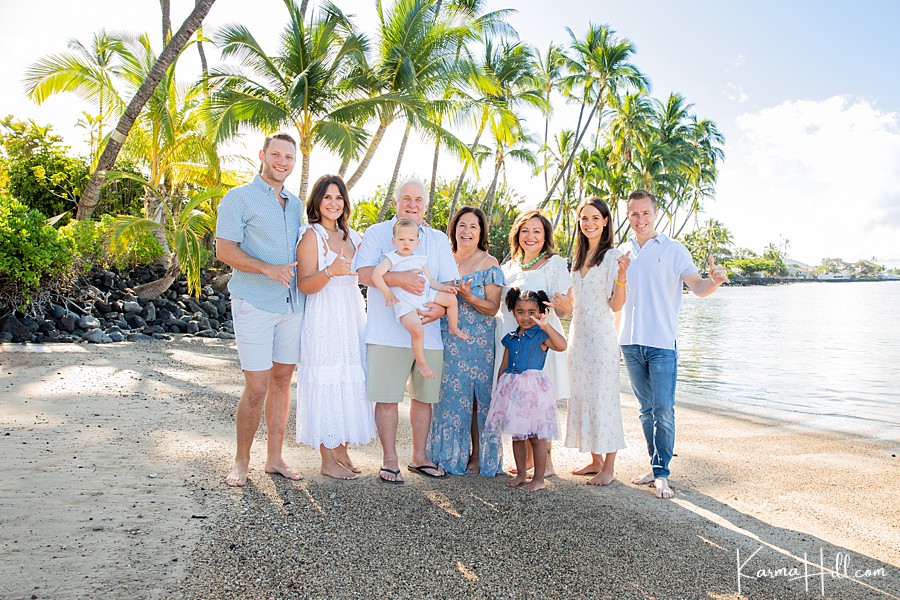 large family on beach pose for photo with shaka 