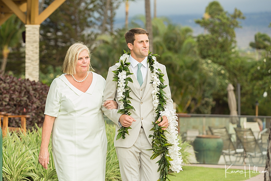 groom walking down the aisle with mother