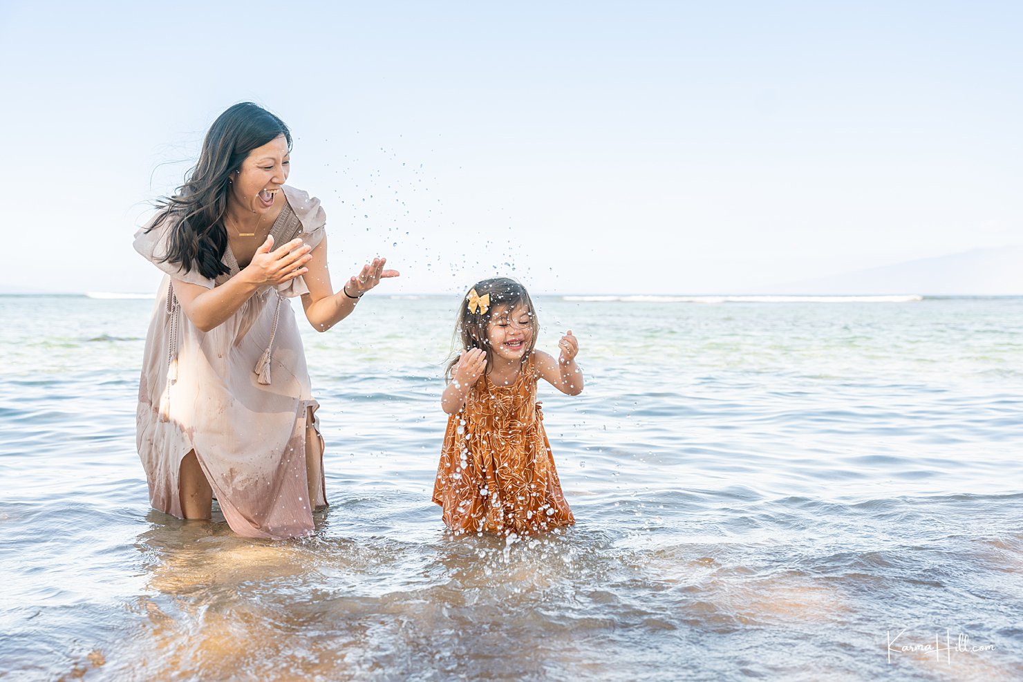 mother and daughter playing in ocean