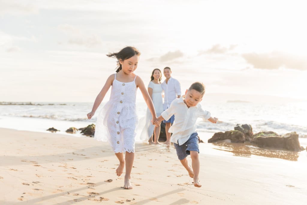 Kid playing during Maui beach photoshoot, running in the sand